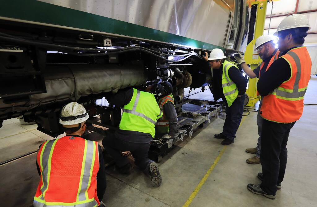 Workers install a rebuilt engine with a new crankshaft into a SMART train at the Rail Operations Center in Santa Rosa on Saturday, December 3, 2016. (John Burgess/The Press Democrat)