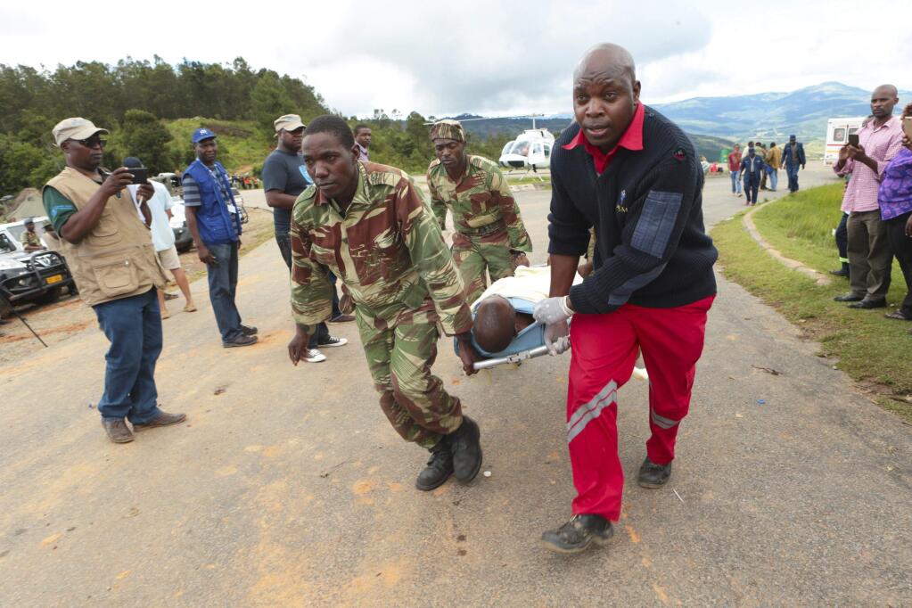Soldiers and paramedics carry injured survivors from a helicopter in Chimanimani about 600 kilometres south east of Harare, Zimbabwe, Tuesday, March, 19, 2019. According to the government, Cyclone Idai has killed more than 100 people in Chipinge and Chimanimani and according to residents the figures could be higher because the hardest hit areas are still inaccesible. Some hundreds are dead, many more are missing, and some thousands at risk from the massive flooding in Mozambique, Malawi and Zimbabwe caused by Cyclone Idai.(AP Photo/Tsvangirayi Mukwazhi)