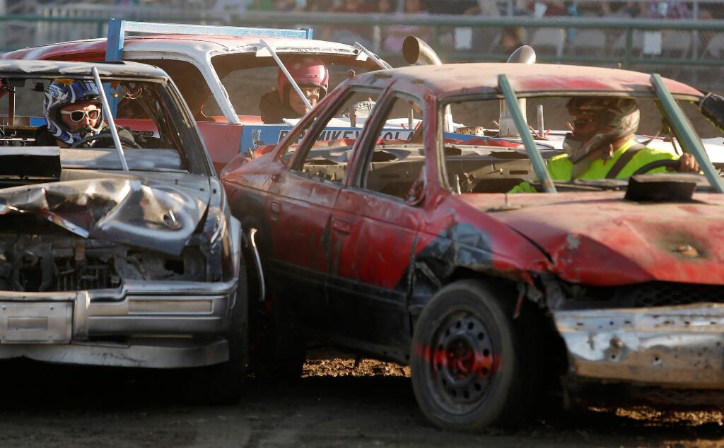 Drivers Jesse Martin, left, David Flint, and Chris Dredge, right, get their cars into a scrum during the Destruction Derby at the Sonoma County Fair in Santa Rosa, California, on Sunday, August 13, 2017. (Alvin Jornada / The Press Democrat)