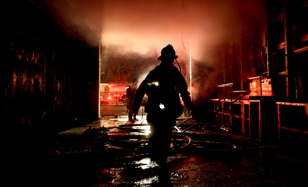 Santa Rosa firefighters mop up at the scene of a warehouse fire on Central Avenue, early Sunday, Jan 29, 2023.  (Kent Porter/The Press Democrat)