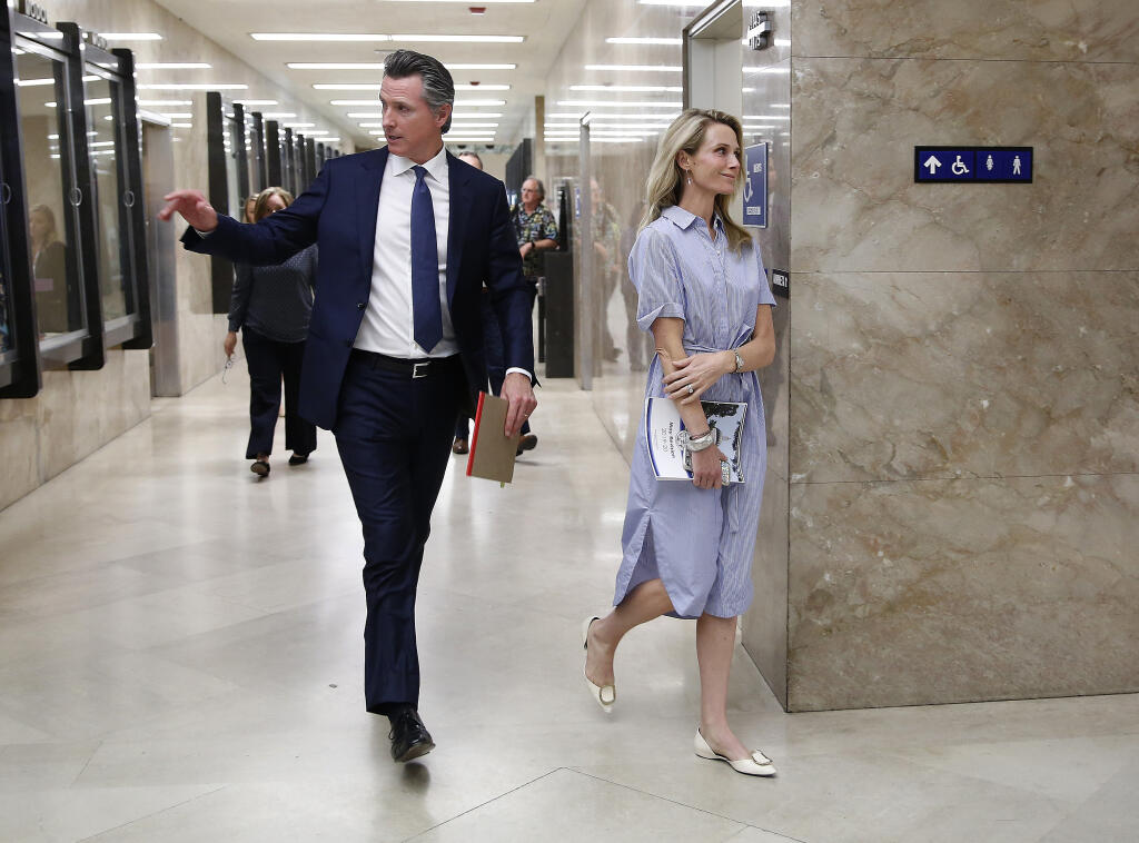 FILE - In this May 9, 2019, file photo, California Gov. Gavin Newsom and his wife, First Partner Jennifer Siebel Newsom, return to the Governor's Office after a news conference in Sacramento, Calif. California Gov. Gavin Newsom said he “absolutely” sees no conflict of interest with a nonprofit launched by his wife accepting donations from companies that lobby his administration.  (AP Photo/Rich Pedroncelli, File)