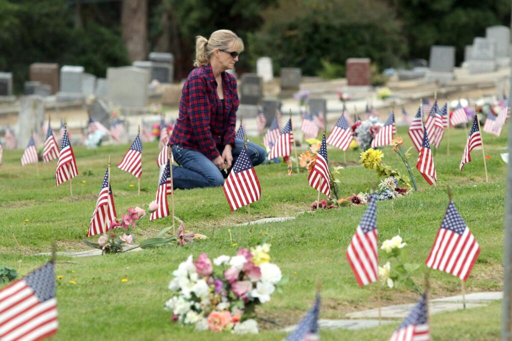 Marilyn Warner of Rohnert park spends time at the grave of her dad Lowell Cole, who served as a Master Sargent in the Air Force, at Cypress Hill Memorial Park in Petaluma on the morning of Memorial Day on May 25, 2015. (SCOTT MANCHESTER/ARGUS-COURIER STAFF)