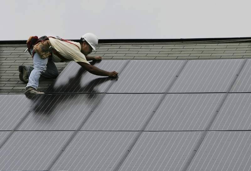 Martin Hernandez secures a solar panel on a house in Mullica Hill, New Jersey, August 30, 2006. A crew from Mesa Environmental Sciences will install a total of 56 panels. (Michael S. Wirtz/Philadelphia Inquirer/MCT)