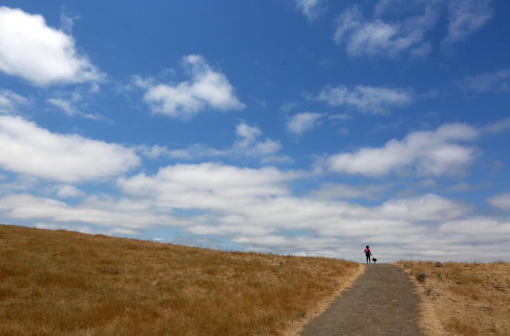 Cathy Alvillar walks her dog on the east trail in the Taylor Mountain Regional Park and Open Space Preserve.