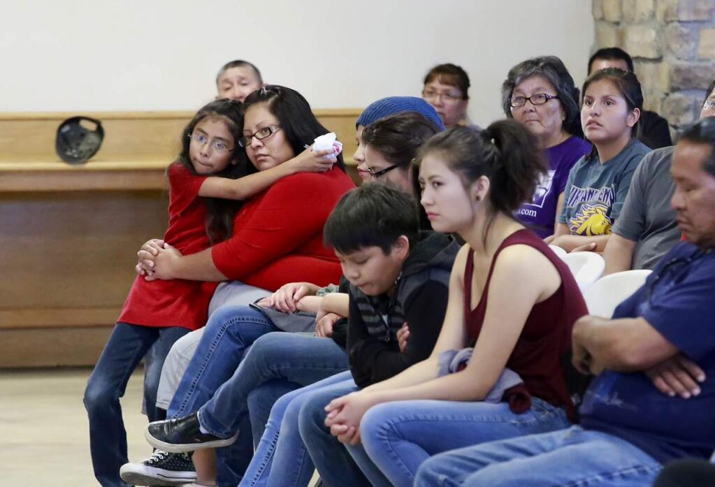 Kynareth Longoria, 7, left, and Letitia Buck, second from left, and other family members mourn for Ashlynne Mike during a vigil for her at the Nenahnezad Chapter House., on Wednesday, May 4, 2016, in Fruitland, N.M. Tom Begaye Jr. was arrested later Tuesday in the death of 11-year-old Ashlynne Mike. He made his first appearance Wednesday before a federal magistrate in Farmington. (Steve Lewis/The Daily Times via AP)