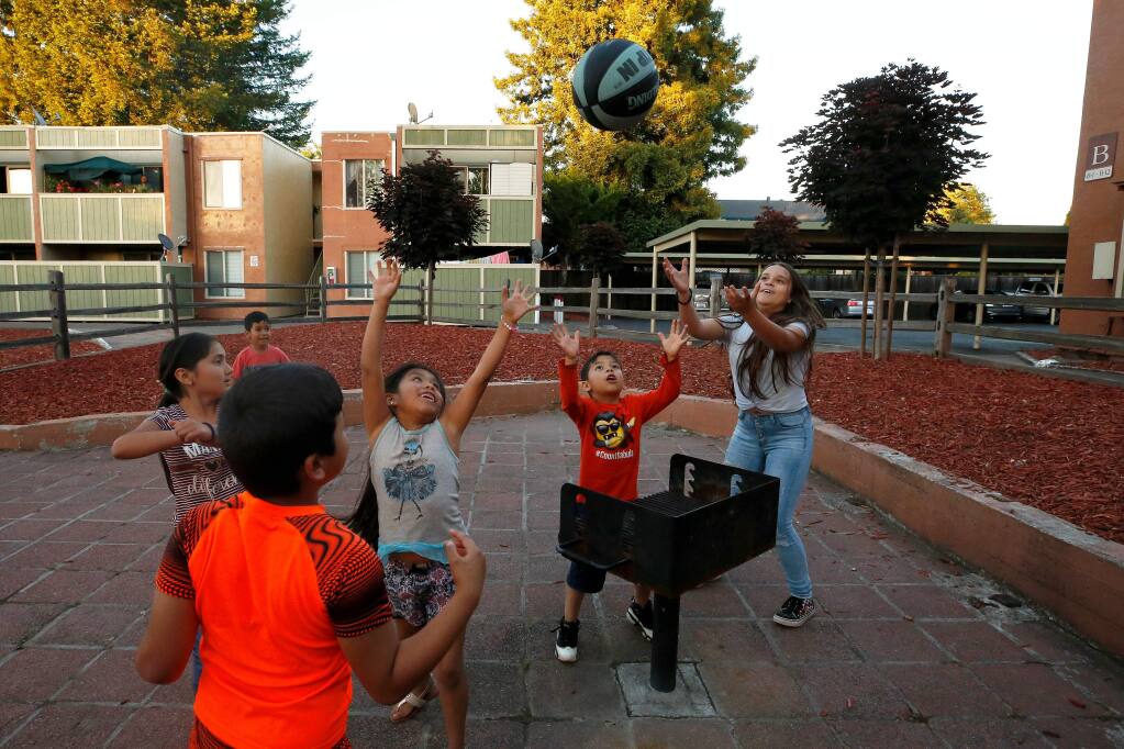 Children play an improvised basketball game using a barbecue as the basket, at Puerta Villa apartments in Santa Rosa, California, on Thursday, June 6, 2019. (Alvin Jornada / The Press Democrat)