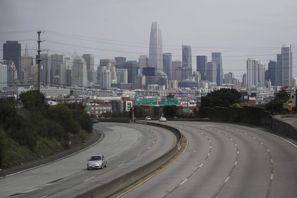 FILE - In this March 29, 2020, file photo, traffic is sparse on Highway 101 in San Francisco amid coronavirus concerns. Citing the unprecedented challenges created by the coronavirus pandemic, city officials across California are asking Gov. Gavin Newsom to suspend or delay numerous state laws, saying they can't comply with everything from environmental regulations to public records laws that allow the public to see how the government spends public money. (AP Photo/Jeff Chiu, File)