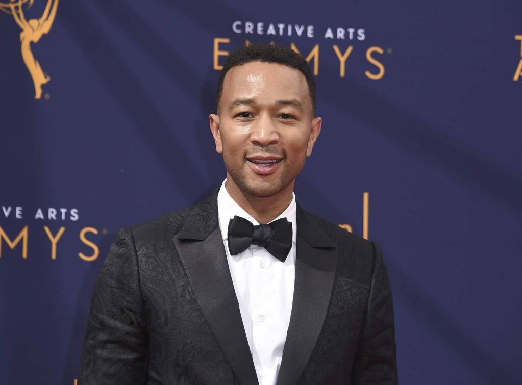 FILE - In this Sept. 9, 2018 file photo, John Legend arrives at the Creative Arts Emmy Awards in Los Angeles. Legend will become a coach on NBC‚Äôs ‚ÄúThe Voice.‚Äù (Photo by Richard Shotwell/Invision/AP, File)