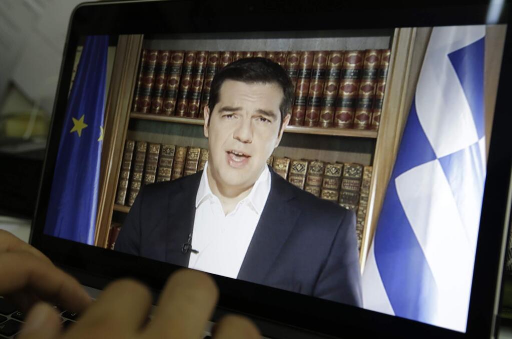 An Associated Press TV producer edits the video of Greece's Prime Minister Alexis Tsipras televised address to the nation in Athens, Friday, July 3, 2015. Tsipras has called on voters to reject creditors' proposals for more austerity in return for rescue loans. He said that Sunday's referendum is not a vote on whether Greece will remain in the euro. (AP Photo/Thanassis Stavrakis)