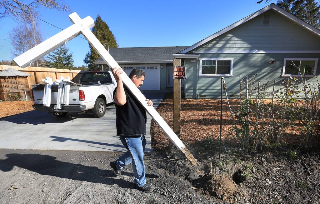 Roberto Valencia of North Bay Signs places a for sale sign post on Montgomery Road in Sebastopol, Wednesday Jan. 15, 2014. (Kent Porter / Press Democrat)