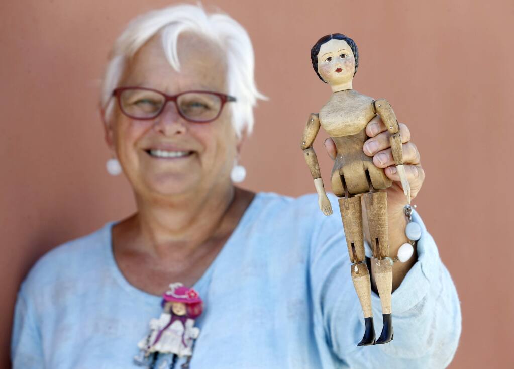 Dr. Geri Olson, the co-curator of the exhibit 'Journeys Through Light and Dark: Dolls as Tellers of Stories' holds a Joel Ellis style doll that she carved and will be featured in the exhibit at the Petaluma Arts Center. Photo taken at the Petaluma Arts Center on Thursday, June 30, 2016 in Petaluma, California . (BETH SCHLANKER/ The Press Democrat)