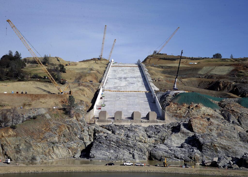 FILE - In this Nov. 30, 2017, file photo, work continues on the Oroville Dam spillway in Oroville, Calif. The city of Oroville plans to sue state water officials for damages caused when thousands of its residents had to be evacuated last year after the Oroville Dam spillways failed. Oroville City Attorney Scott Huber says the city will file the lawsuit Wednesday, Jan. 17, 2018. (AP Photo/Rich Pedroncelli, File)