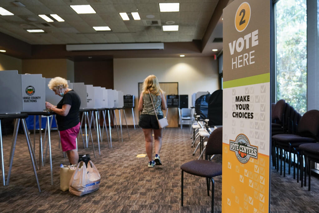 Voters cast ballots in Huntington Beach during the early voting period for the California gubernatorial recall election. (ASHLEY LANDIS / Associated Press)