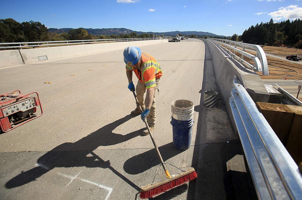 William Deviny gathers cement dust on the Willits bypass, Wednesday Oct. 5, 2016. (Kent Porter / The Press Democrat) 2016