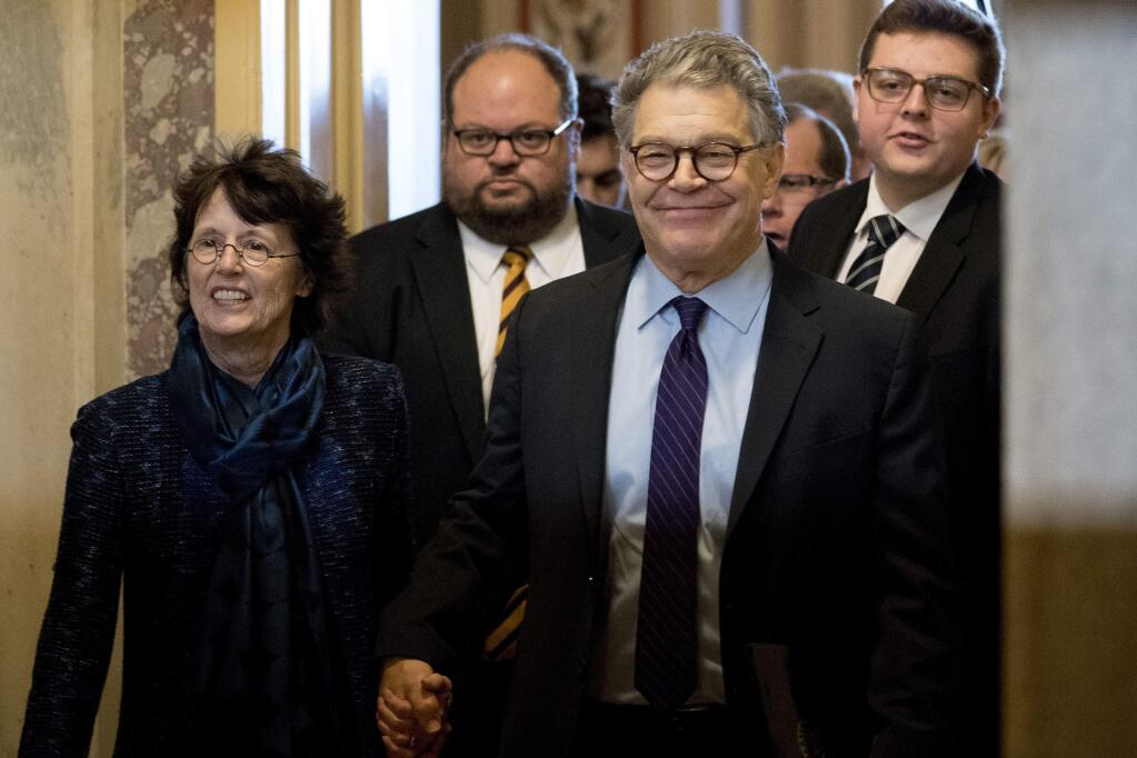FILE - In this Dec. 7, 2017, file photo, Sen. Al Franken, D-Minn., second from right, holds hands with his wife Franni Bryson, left, as he leaves the Capitol after speaking on the Senate floor on Capitol Hill in Washington. Franken says he “absolutely” regrets resigning from the Senate after eight women accused him of unwanted kissing or touching. Franken made the comments in an article published by the New Yorker magazine on Monday, July 22, 2019. (AP Photo/Andrew Harnik, File)