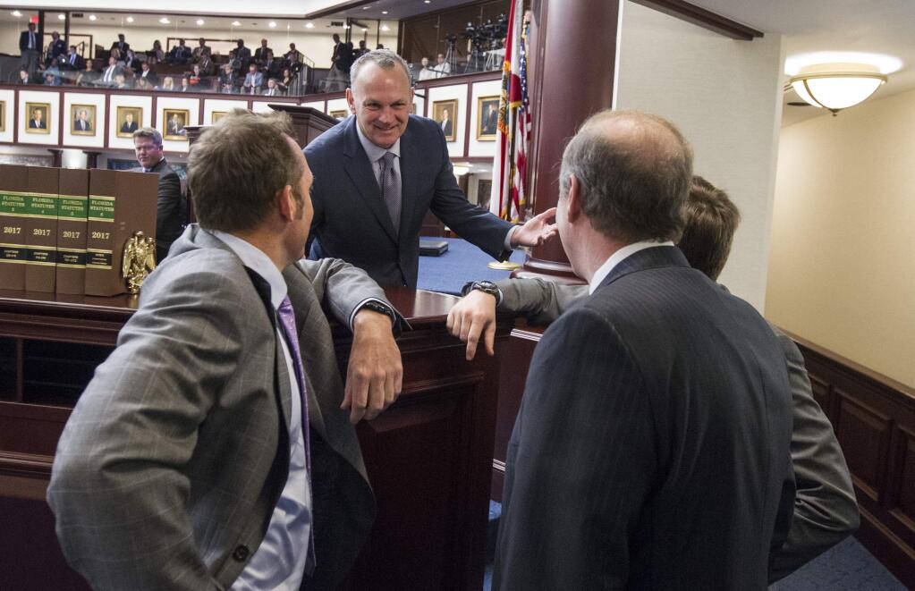 Florida Speaker of the House Rep. Richard Corcoran (R-Lutz) speaks with Representatives and Senators at the dais during the school safety debate on the House floor at the Florida Capital in Tallahassee, Fla., Wednesday March 7, 2018. (AP Photo/Mark Wallheiser)