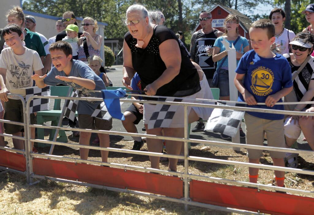Petaluma, CA, USA. Saturday, June 25, 2016._ Janet Tomasek of Rohnert Park (center) cheers loudly and waves the blue flag during the pig races at the 2016 Sonoma-Marin Fair in Petaluma. (CRISSY PASCUAL/ARGUS-COURIER STAFF)