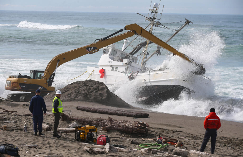 Waves crash on the Aleutian Storm as excavators work to free the fishing vessel on South Salmon Creek Beach north of Bodega Bay, Monday, Feb. 12, 2024. Efforts to refloat the vessel failed after a haul line broke. (Christopher Chung  / The Press Democrat)