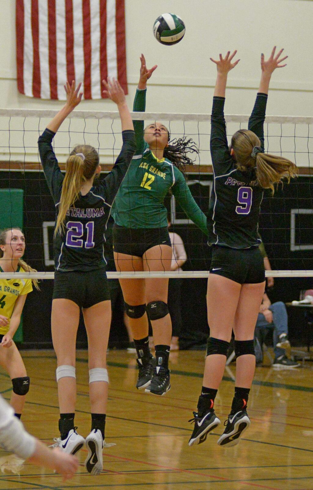 SUMNER FOWLER/FOR THE ARGUS-COURIERCasa Grande' s Lina Fakalata hits over a block attempt by Petaluma's Lily Paschoal and Liah Bacon in match won by Casa, 3-2.