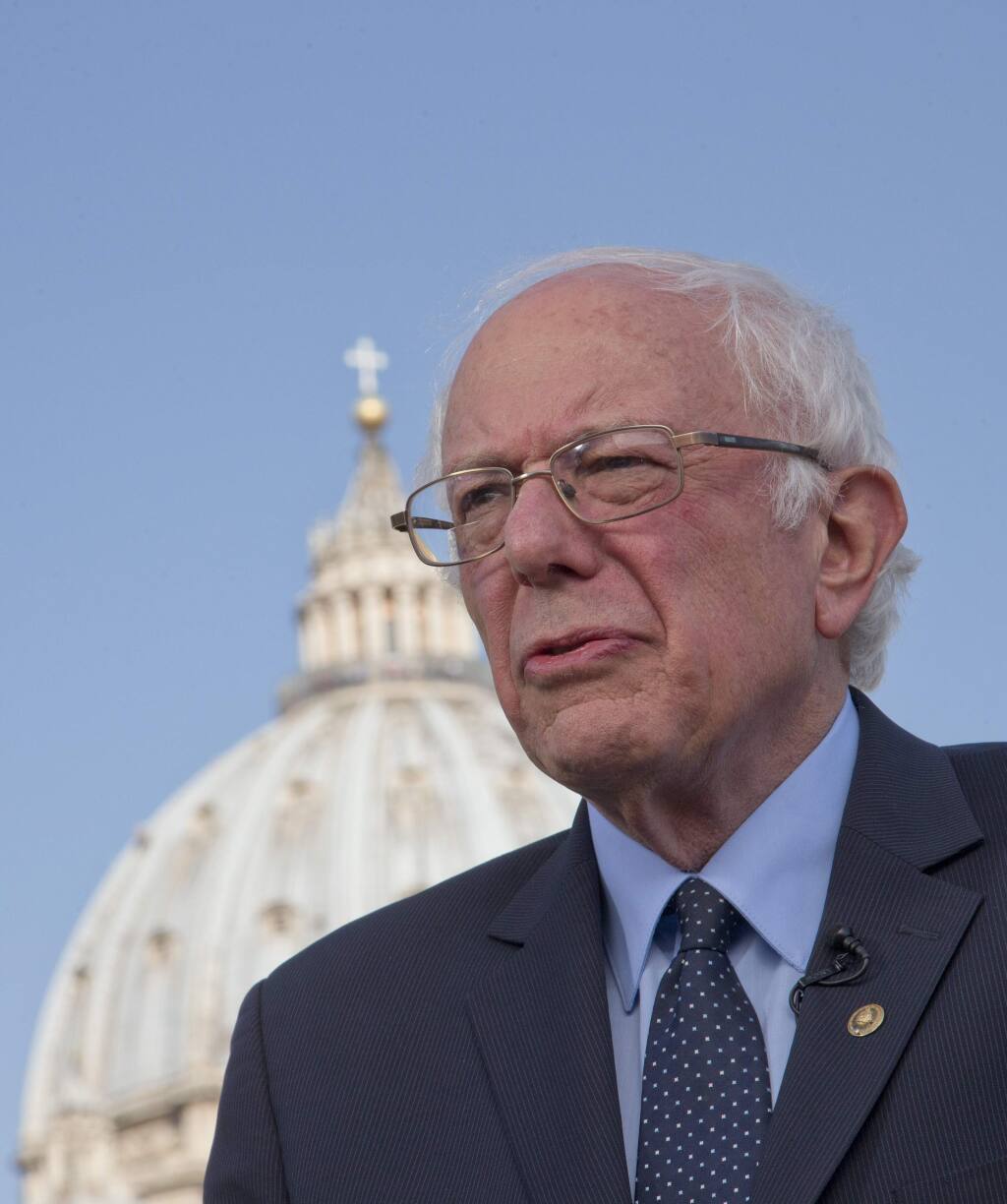 US presidential candidate Bernie Sanders, backdropped by the dome of St. Peter's Basilica, listens to questions during an interview with the Associated Press, at the Vatican Saturday, April 16, 2016. Democratic presidential candidate Bernie Sanders says in an interview with The Associated Press that he met with Pope Francis. Sanders says the meeting took place Saturday morning before the pope left for his one-day visit to Greece. He says he was honored by the meeting, and that he told the pope he appreciated the message that he is sending the world about the need to inject morality and justice into the world economy. (AP Photo/Alessandra Tarantino)