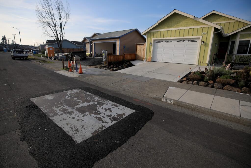 A metal plate covers a PG&E breach of a sewer line on Cashew Road in Coffey Park, that is causing homeowners sewer lines to back up, Friday, Jan. 3, 2020 in Santa Rosa. (Kent Porter / The Press Democrat) 2020