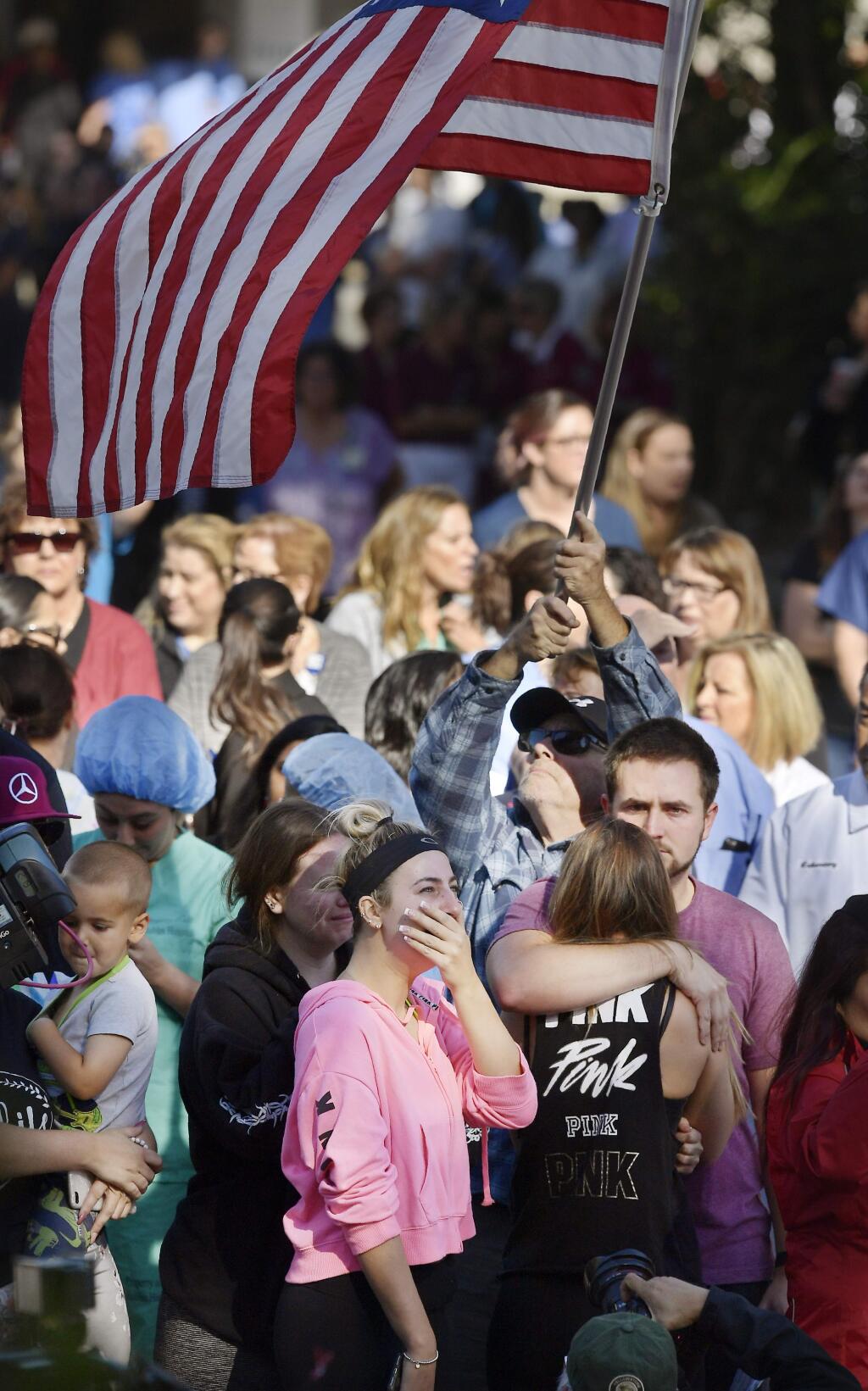 People cry as a law enforcement motorcade escorts the body of Ventura County Sheriff's Department Sgt. Ron Helus from the Los Robles Regional Medical Center Thursday, Nov. 8, 2018, in Thousand Oaks, Calif., after a gunman opened fire Wednesday evening inside a country music bar, killing multiple people including Helus. (AP Photo/Mark J. Terrill)