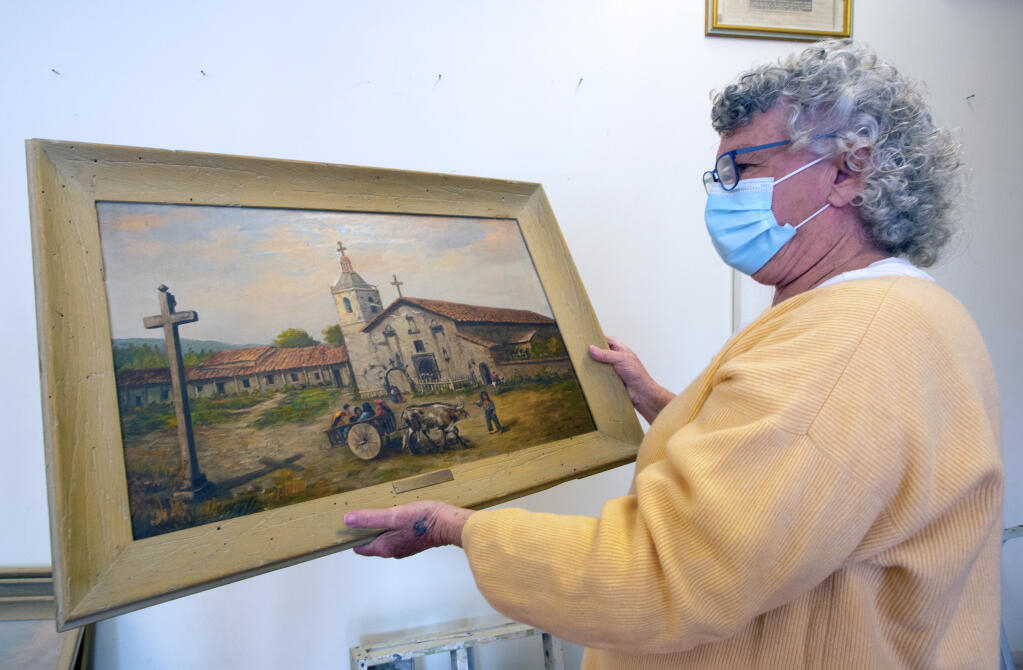 Patricia Cullinan, director of the Depot Park Museum, examines one of the Mission in Santa Clara which had been hanging in the Bank of America on Napa Street, on Monday, Feb. 1. (Photo by Robbi Pengelly/Index-Tribune)