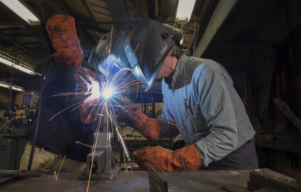 Sonoma Valley High School's metal shop teacher Mark Lea gives Anthony Hernandez, 14, a lesson in welding. (Photo by Robbi Pengelly/Index-Tribune)