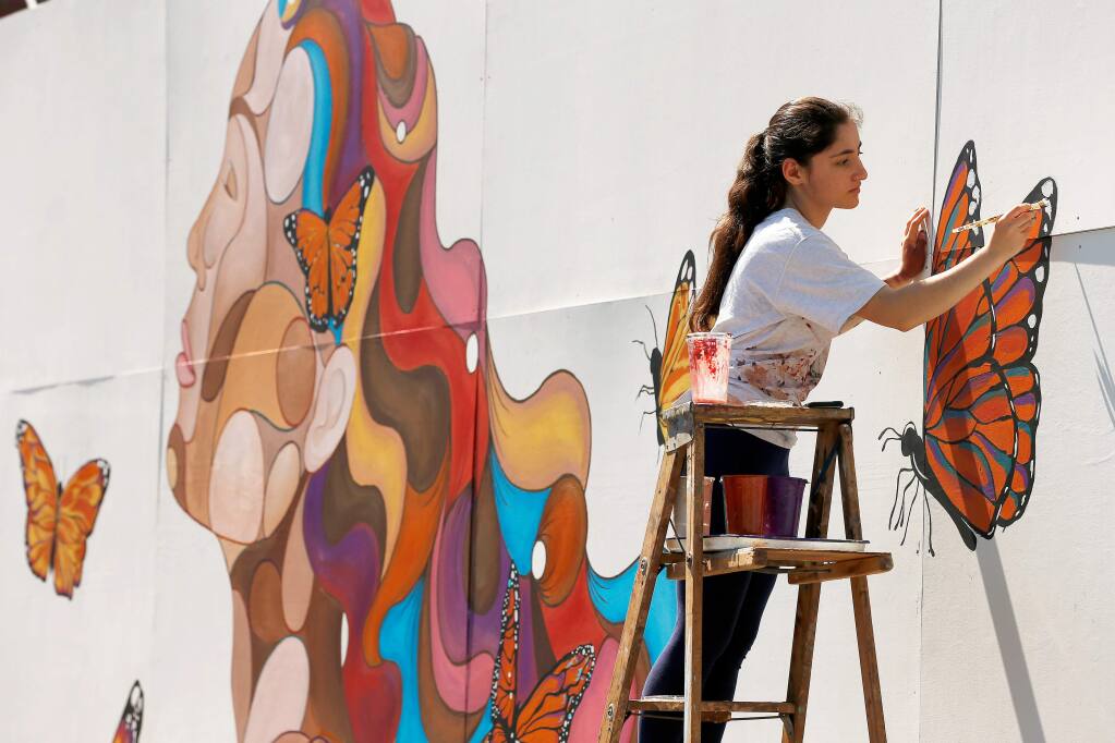 Montgomery High School junior Rima Makaryan, 16, paints details on the Dreamer Mural she created at Montgomery High School in Santa Rosa, California, on Saturday, March 30, 2019. (Alvin Jornada / The Press Democrat)