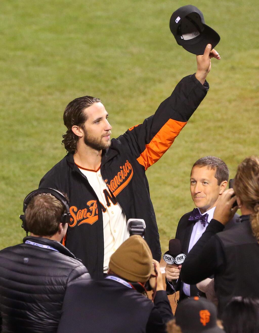 San Francisco Giants starting pitcher Madison Bumgarner tips his hat to the crowd while being interviewed by the media, after pitching a complete game, allowing five hits and no runs, in Game 5 of the World Series in San Francisco on Sunday, October 26, 2014. The Giants defeated the Royals 5-0. (Christopher Chung / The Press Democrat)
