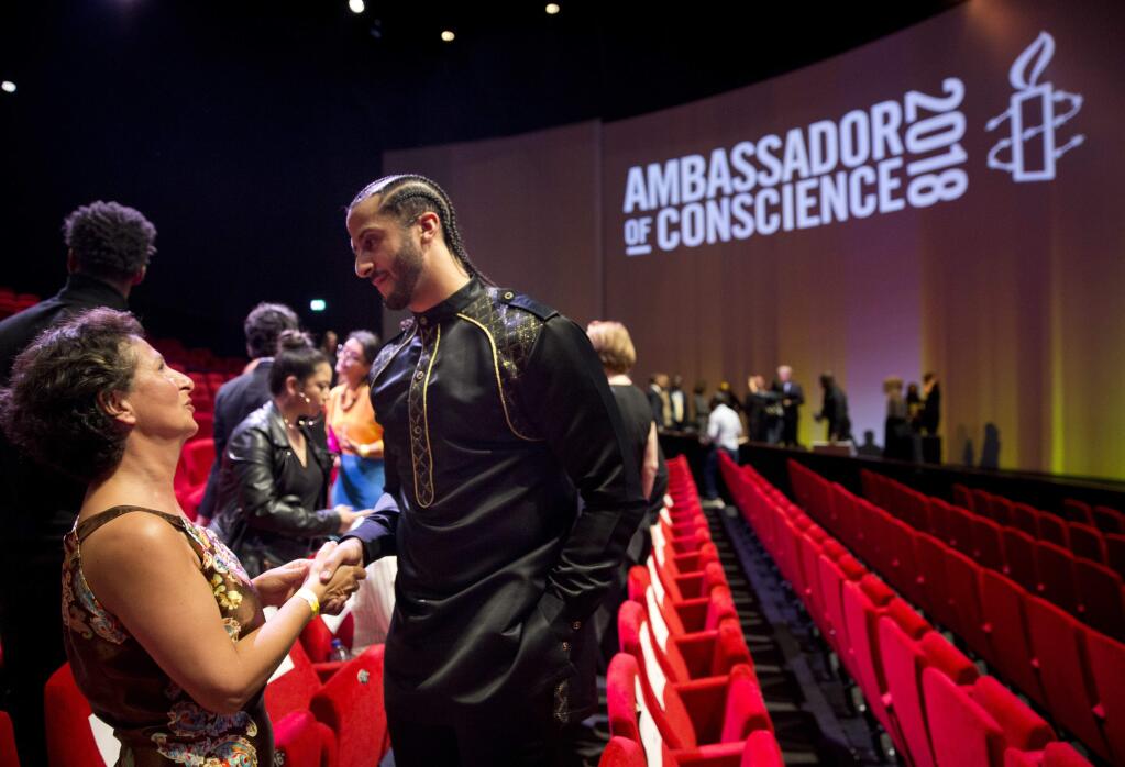 Former NFL quarterback and social justice activist Colin Kaepernick talks to guests after receiving the Amnesty International Ambassador of Conscience Award for 2018 in Amsterdam, Saturday April 21, 2018. Kaepernick became a controversial figure when refusing to stand for the national anthem, instead he knelt to protest racial inequality and police brutality. (AP Photo/Peter Dejong)