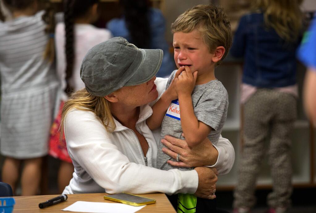 Holly Michalek comforts her neighbor's son, Kellen Curry, 4, before the start of class on the first day kindergarten at Hidden Valley Elementary School in Santa Rosa. (photo by John Burgess/The Press Democrat)