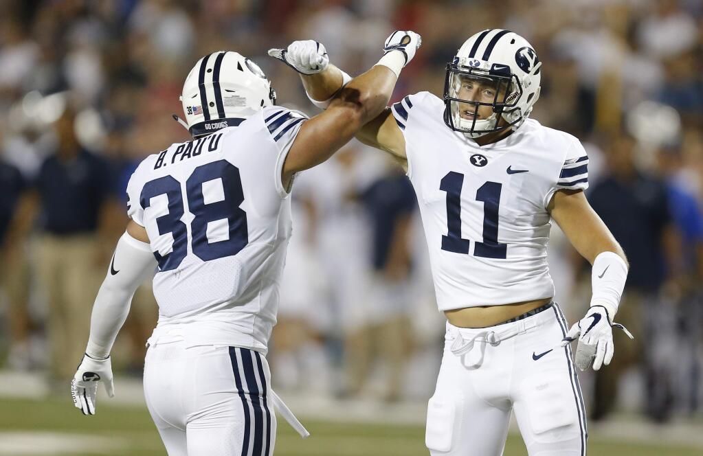 In this Sept. 1, 2018, file photo, Brigham Young linebacker Butch Pau'u (38) and Austin Lee celebrate after breaking up a pass in the second half against Arizona, in Tucson, Ariz. (AP Photo/Rick Scuteri, File)