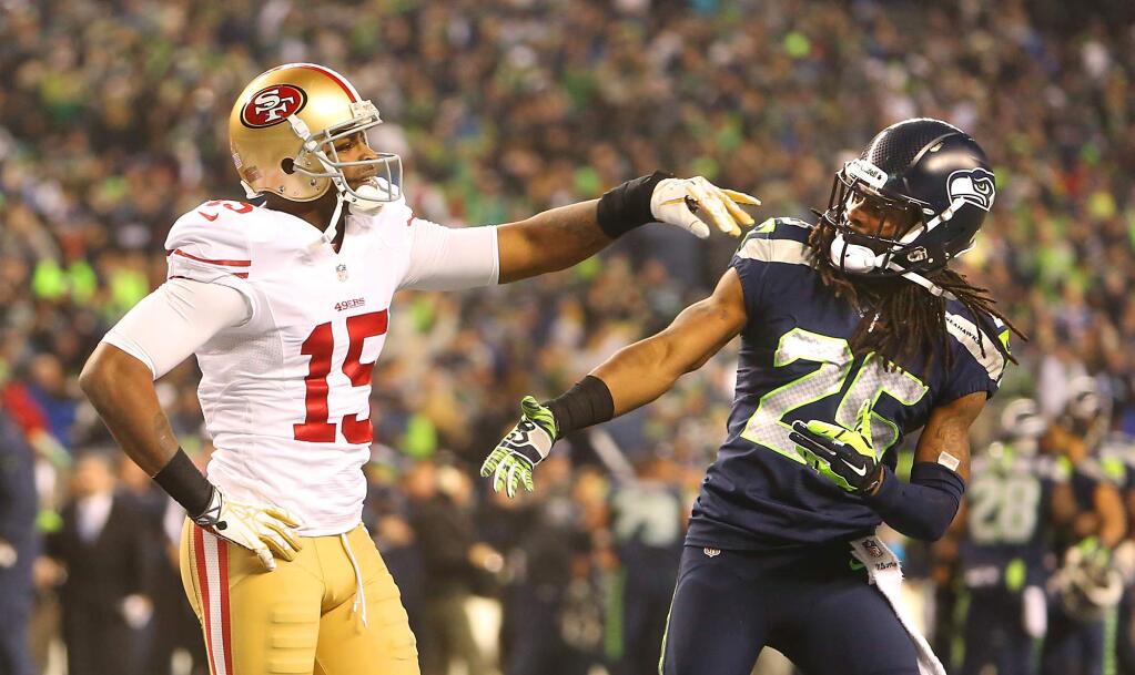 Richard Sherman goes up to shake Michael Crabtree's hand after he tapped away the ball in the end zone to seal the victory. Crabtree was not amused. The Seahawks beat the 49ers, 23-27, at CenturyLink Field in Seattle on Sunday, January 19, 2014. (John Burgess/For The Press Democrat)