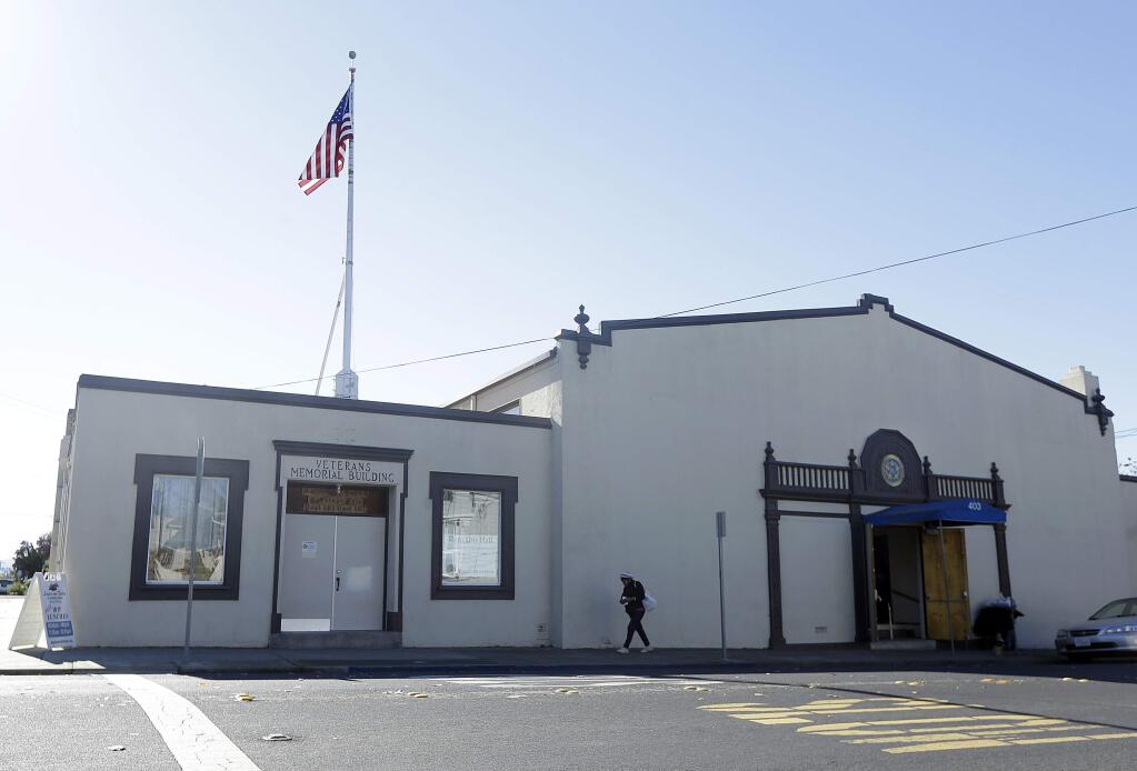 A woman walks in front of the American Legion Hall, which served a free Thanksgiving dinner, in Antioch, Calif., Tuesday, Nov. 29, 2016. San Francisco Bay Area health officials were trying to determine if three people who died and five who were sickened after eating the Thanksgiving dinner at a church event held at the American Legion Hall got sick there or at the assisted living facility where they all lived. (AP Photo/Jeff Chiu)
