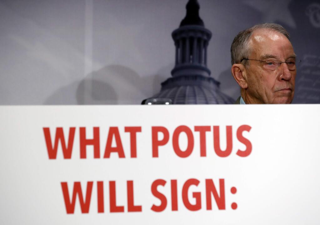 Sen. Chuck Grassley, R-Iowa, stands in front of a graphic during a news conference about an immigration bill on Capitol Hill, Monday, Feb. 12, 2018 in Washington. (AP Photo/Alex Brandon)