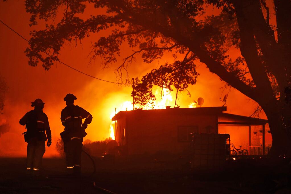 Firefighters from Northshore Fire Protection District can only watch as a home succumbs to flames as they arrive on scene, during the Ranch Fire off New Long Valley Road near Clearlake Oaks, California, on Saturday, August 4, 2018. (Alvin Jornada / The Press Democrat)