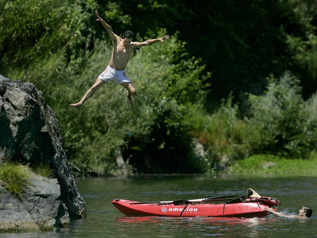 Lukas Nelson of Los Angeles jumps from Eagle Rock in to the Russian River, Saturday June 27, 2009 at the foot of Fitch Mountain in Healdsburg. Across from the rock, 18 year-old Honza Ripa became paralyzed jumping from the beach on June 13. In the past, other teens have been paralyzed by jumping off Eagle Rock. (Kent Porter / Press Democrat) 2009