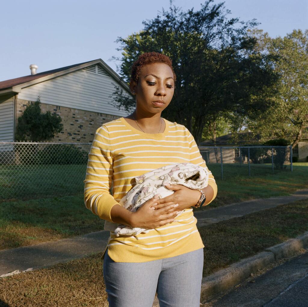Chasisty Bee holds a baby blanket in memory of her 2014 miscarriage, in Memphis, Tenn., Oct. 8, 2018. In 2014, while Chasisty Bee was pregnant, her supervisors at the Verizon warehouse in Memphis refused to grant her request for light duty. One day, she collapsed at work. She later miscarried. (Miranda Barnes/The New York Times)