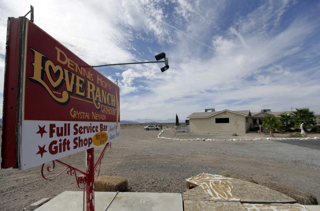 FILE - In this Oct. 14, 2015, file photo, a sign advertises Dennis Hof's Love Ranch brothel in Crystal, Nev. County officials in Nevada have yanked a brothel license from the state's most famous pimp who has fashioned himself as a Donald Trump-style candidate for Nevada's legislature. Officials in Southern Nevada's Nye County on Tuesday said Dennis Hof had failed to apply for a renewal and pay fees for his Love Ranch brothel in Crystal, about an hour's drive northwest of Las Vegas. (AP Photo/Chris Carlson, File)