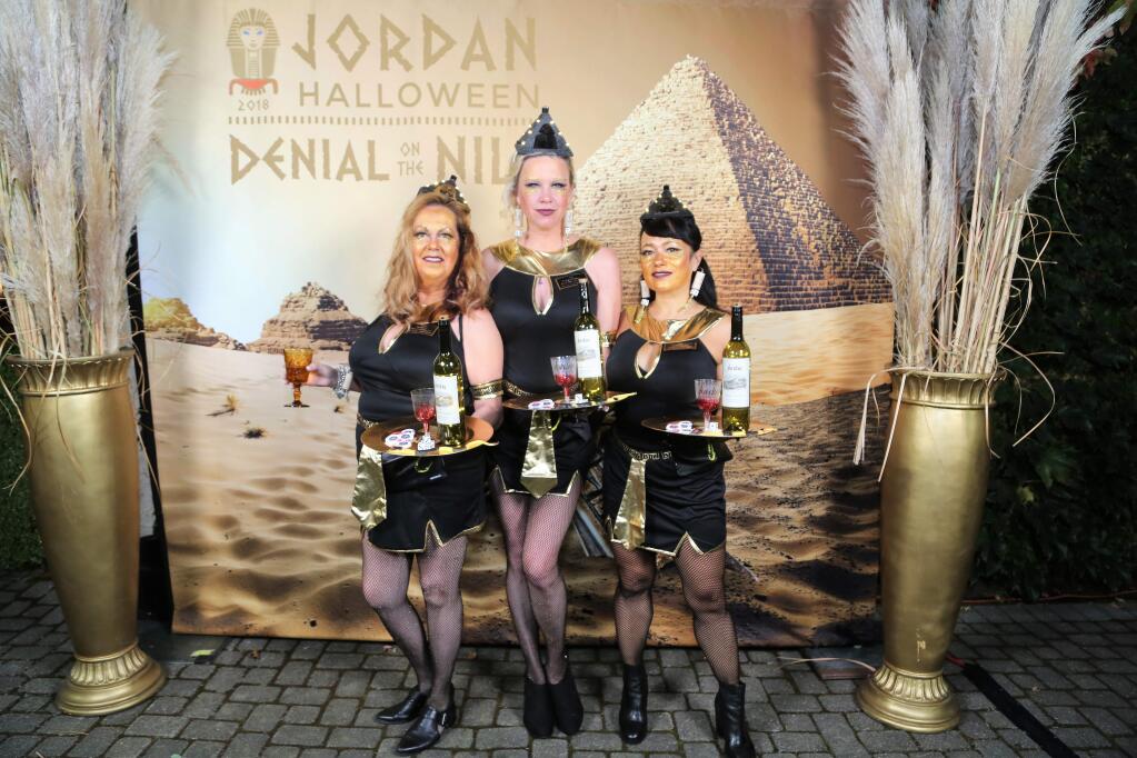 From left, Tammie Ruesenberg, Sarah Pollack, and Chloe Helfand, dressed as Luxor Hotel cocktail waitresses, pose for photos at Jordan Winery's annual Halloween party held in the barrel room of the winery on Saturday, Oct. 20, 2018. (Will Bucquoy/For the PD)