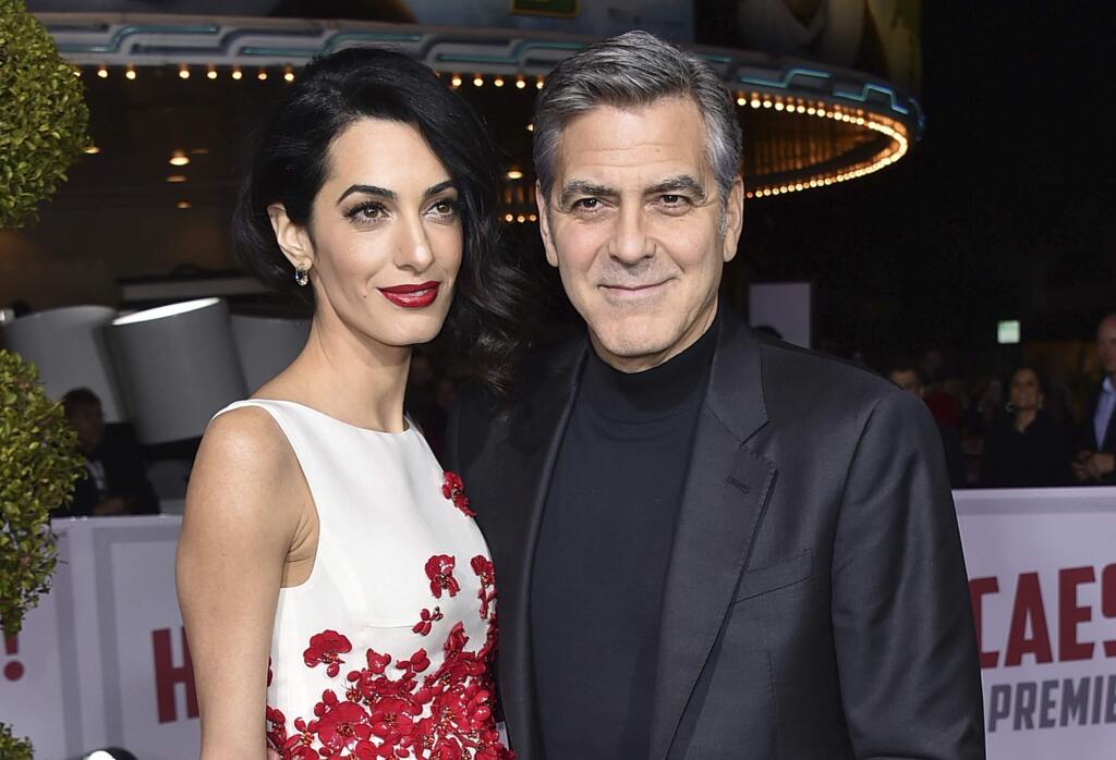 FILE - In this Feb. 1, 2016 file photo, Amal Clooney, left, and George Clooney arrive at the world premiere of 'Hail, Caesar!' in Los Angeles. George and Amal Clooney have welcomed twins Ella and Alexander Clooney. The pair was born Tuesday morning, June 6, 2017, according to George Clooney's publicist Stan Rosenfield. (Photo by Jordan Strauss/Invision/AP, File)