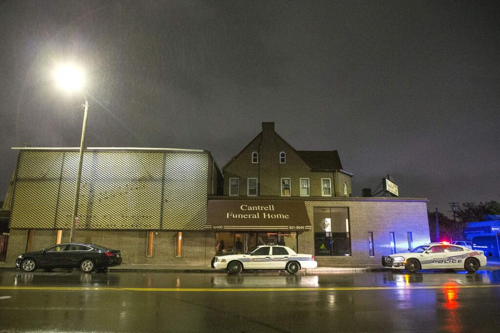 Detroit Police vehicles are parked outside of the Cantrell Funeral Home in Detroit on Friday, Oct. 12, 2018. Police said an anonymously written letter led inspectors to find the decomposed remains of 11 infants hidden in a ceiling compartment of the shuttered funeral home. (Junfu Han/Detroit Free Press via AP)