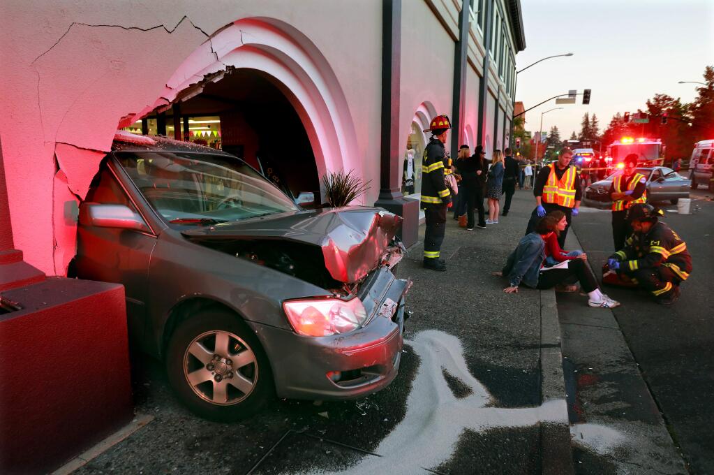 A car end up crashing through the archway of the Crossing the Jordan Lash Studio and Beauty Bar on B St. in Santa Rosa on Saturday night after it was pushed by an oncoming car that accelerated through a red light at 4th St. (photo by John Burgess/The Press Democrat)