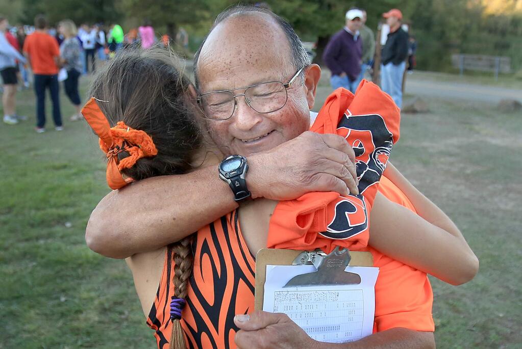 Santa Rosa's Delaney White is congratulated by her coach, Doug Courtemarche, after White won her fourth straight NBL cross country title at Spring Lake in Santa Rosa, Friday Nov.6, 2015. (Kent Porter / Press Democrat)