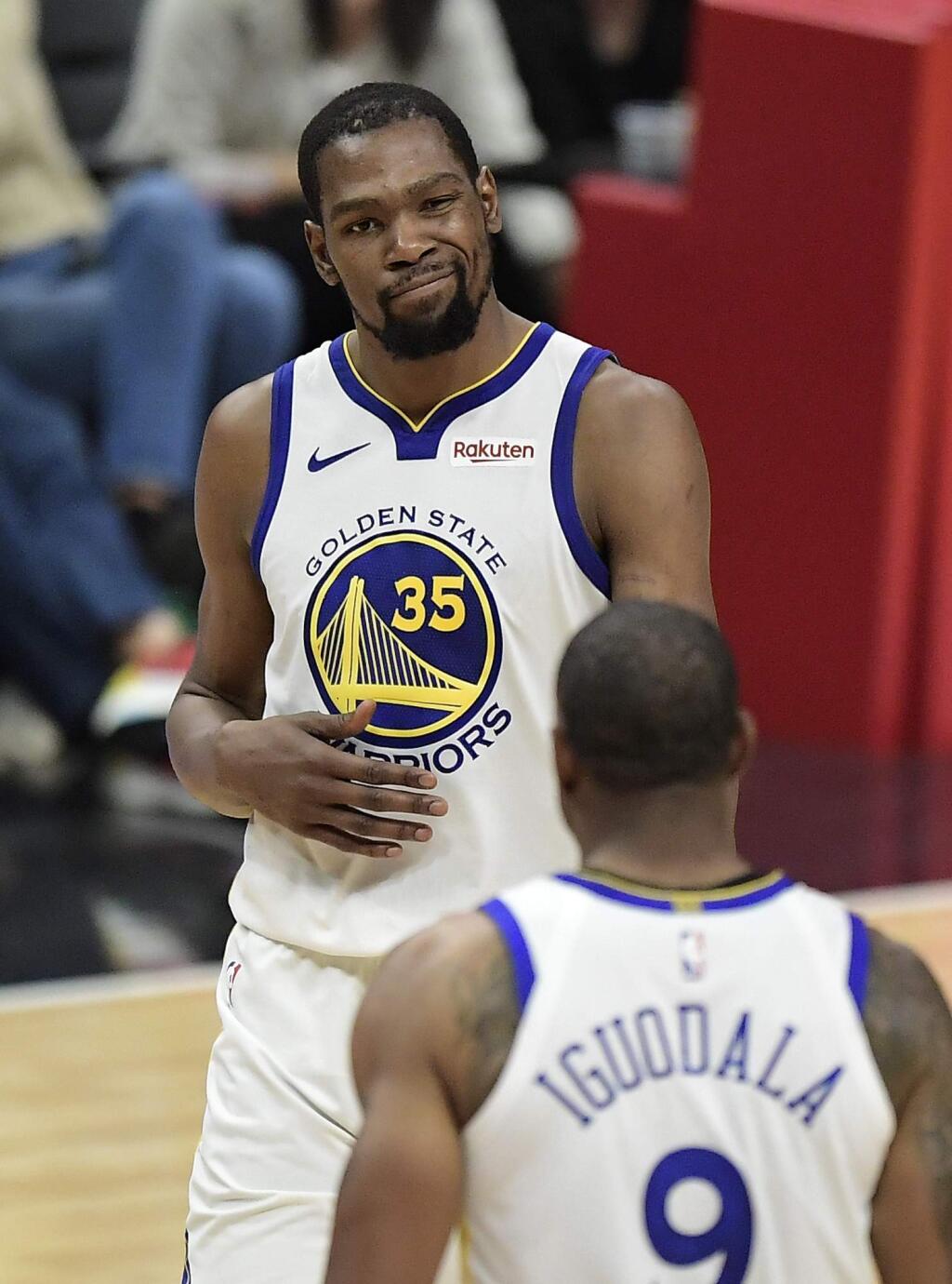 Golden State Warriors forward Kevin Durant, top, winks at guard Andre Iguodala during the second half in Game 6 of a first-round playoff series against the Los Angeles Clippers Friday, April 26, 2019, in Los Angeles. (AP Photo/Mark J. Terrill)