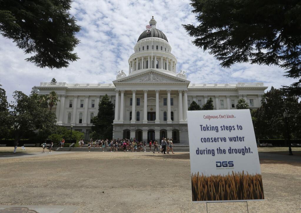 A sign alerts visitors to water conservation efforts at the state Capitol, Tuesday, July 8, 2014, in Sacramento, Calif. (AP Photo/Rich Pedroncelli)
