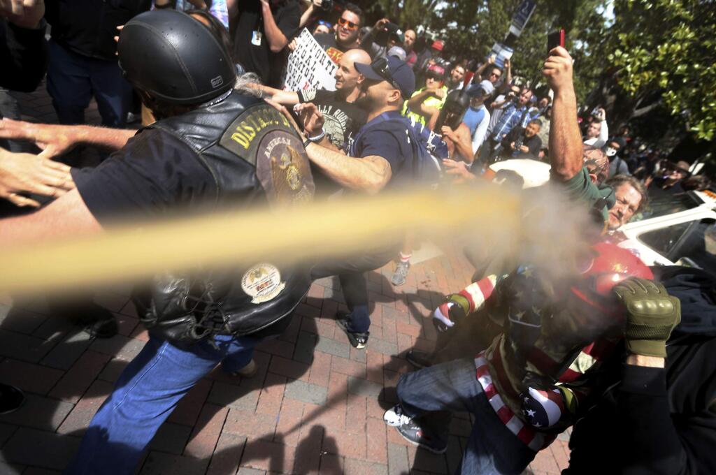 FILE - In this April 15, 2017 file photo, pepper spray is used as anti and pro-Donald Trump protesters clash during competing demonstrations at Martin Luther King Jr. Civic Center Park in Berkeley, Calif. Police in Berkeley, California say they need an additional weapon to combat violent protests that have repeatedly hit the city. The city council will decide Tuesday, Sept. 12, whether to let officers use pepper spray to control crowds that turn violent. (Anda Chu/San Jose Mercury News via AP, File)