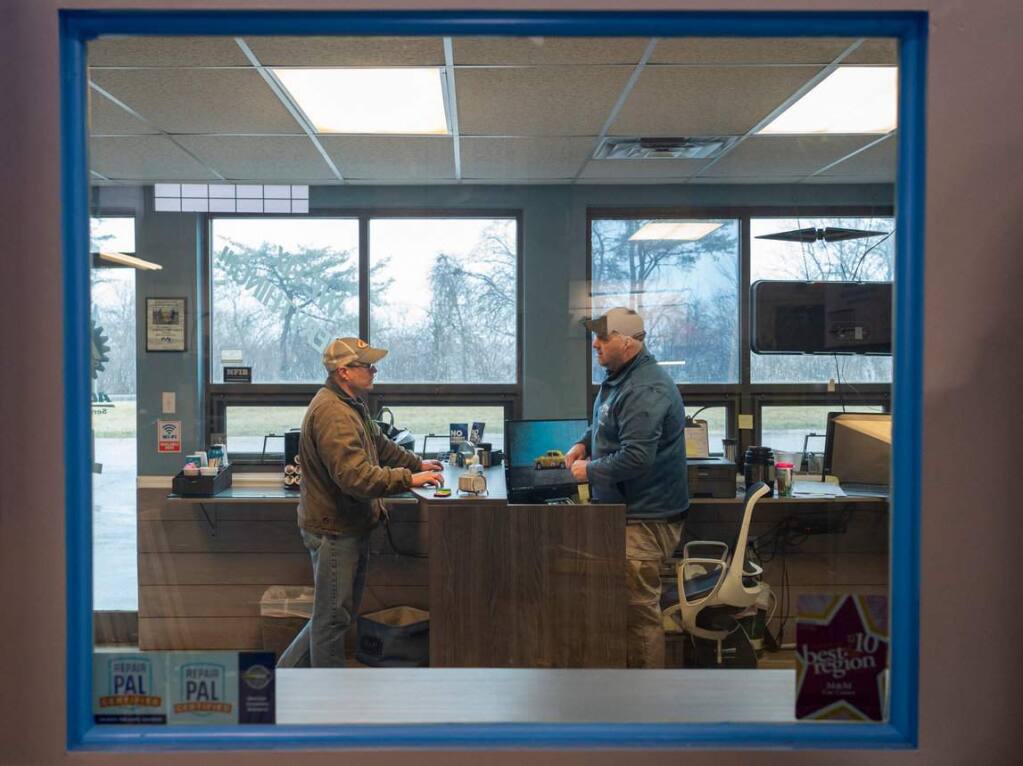 Jason Smith, right, speaks with Mike Gillette at M&M Car Care Center in Merrillville, Indiana, on Wednesday, March 18, 2020. 'We started out the month well,' Smith said. 'As soon as the virus started spreading, everything just went completely empty.' (Youngrae Kim for The Washington Post)