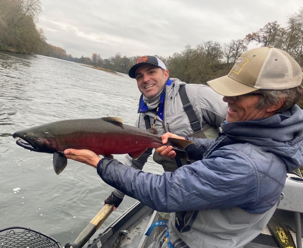 Fishing guide Jim Andras holds up the 12-pound coho salmon that Chris Lynch caught last Saturday while fly-fishing for steelhead on the Rogue River. Chris and Jim Lynch caught and released 18 steelhead and the salmon in two days of fishing. (Photo: Jim Lynch)